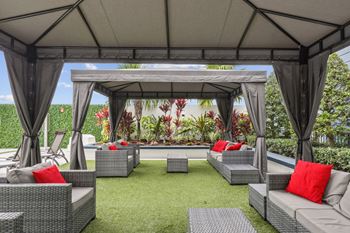 Outdoor lounge area with covered cabanas at Bay Village 1 Apartment in Palmetto Bay, FL